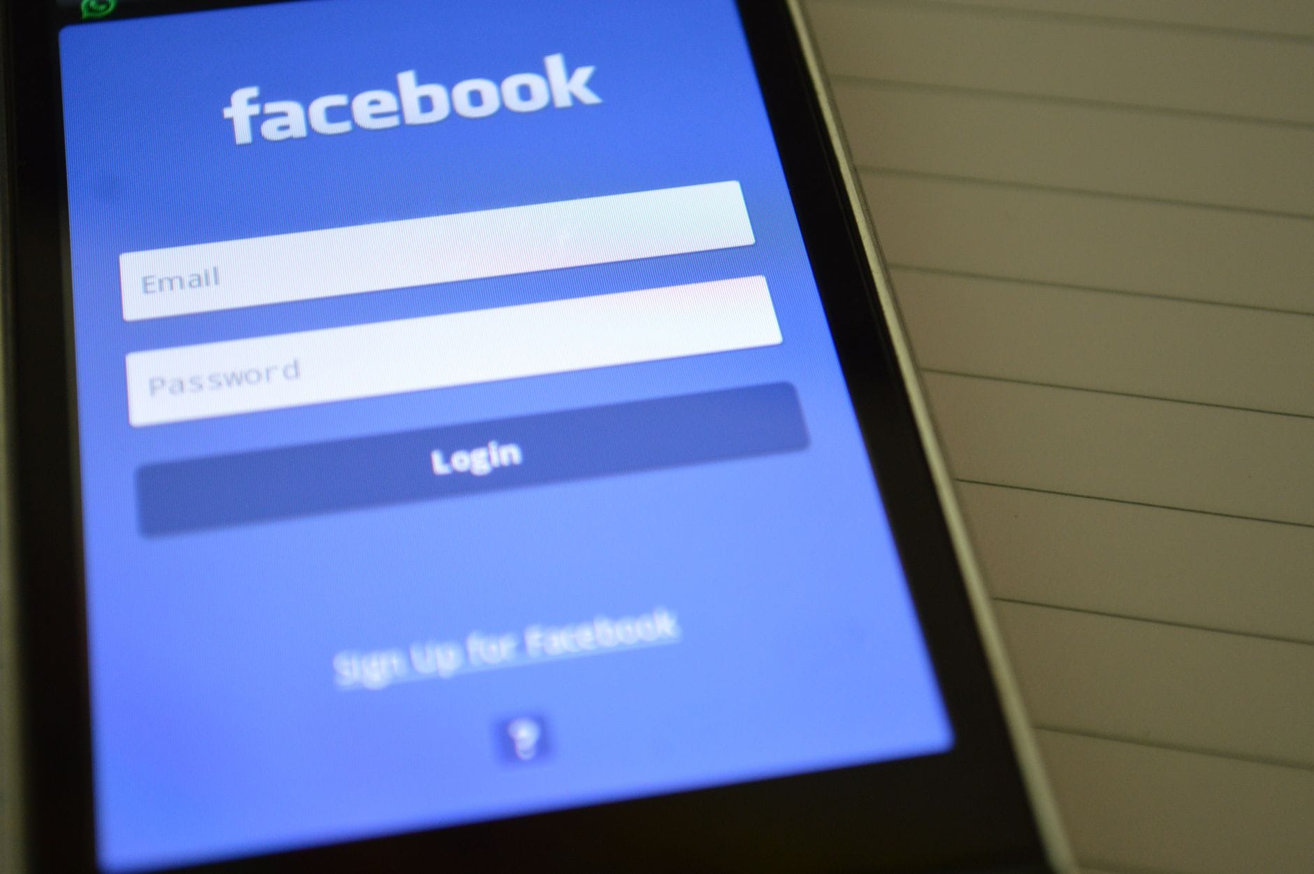 Ekran logowania Facebooka na smartfonie trzymanym w dłoni